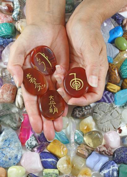 etched with Reiki symbols against a background of random tumbled crystal stones